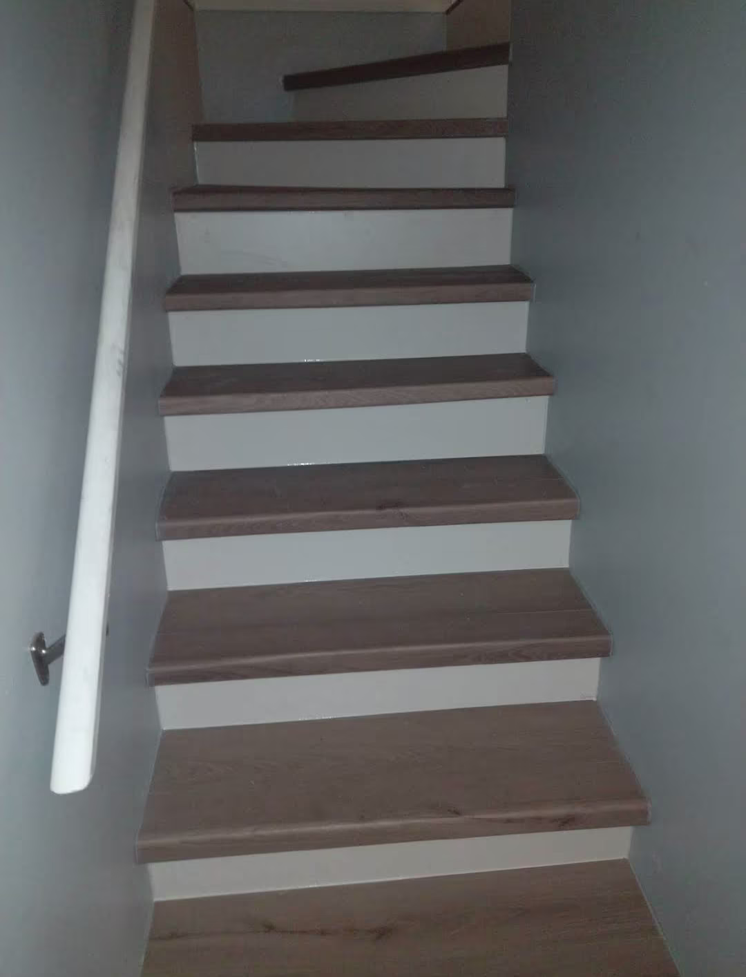 Main staircase with wood treads, white risers, and a white handrail